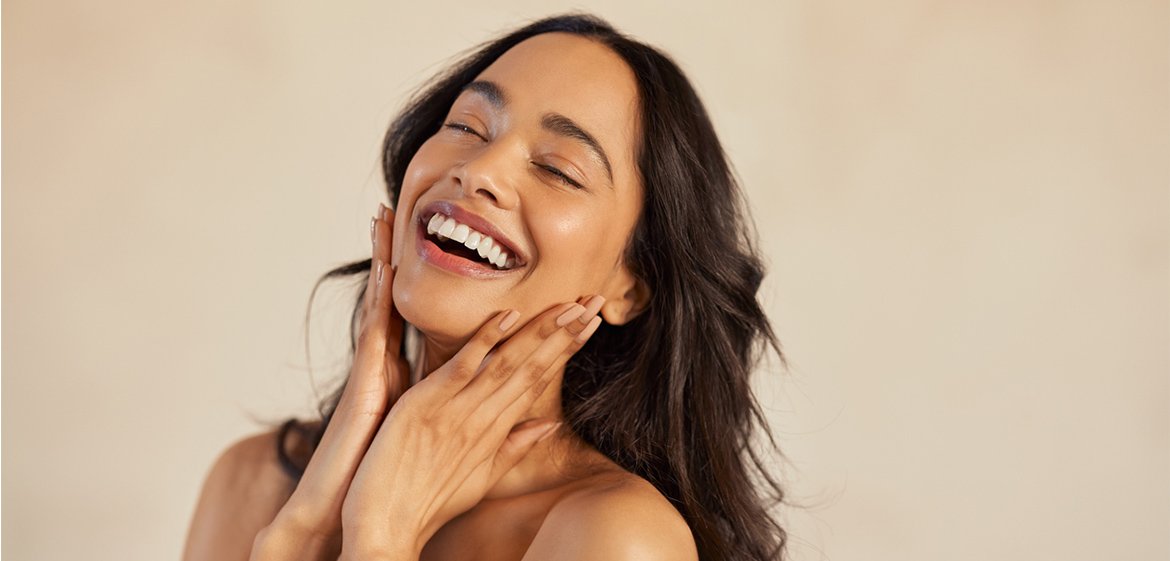 Eine Frau mit geschlossenen Augen grinst